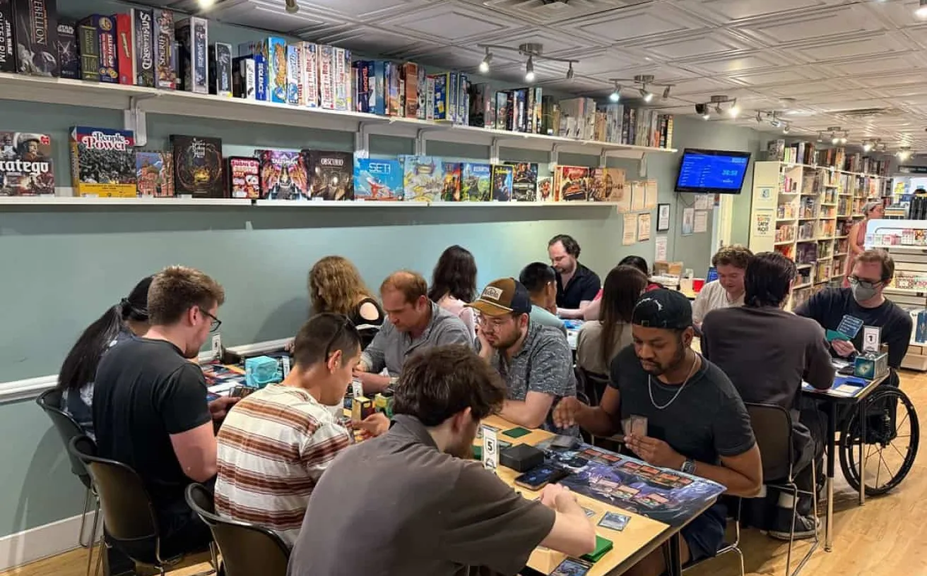 People playing board games at tables inside Stardust Video and Coffee in Audubon Park