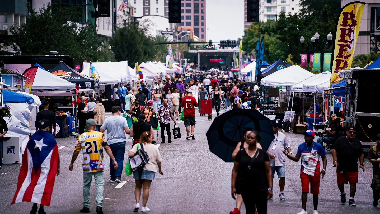 Crowds and vendor tents filling Orange Avenue during Fiesta Calle Orange in downtown Orlando