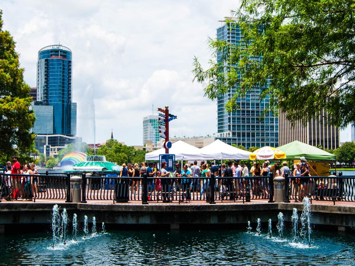 Shoppers browsing vendor tents at Orlando Farmers Market at Lake Eola