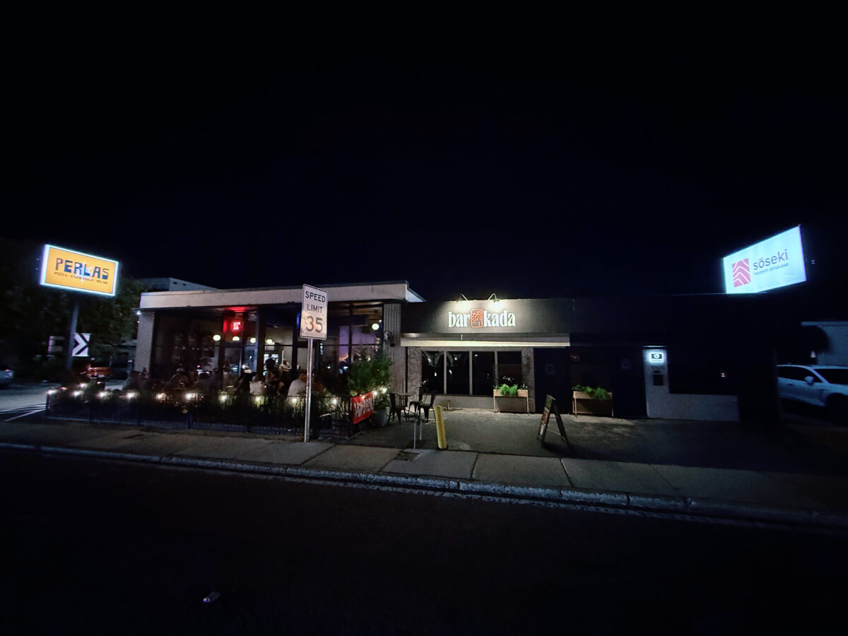 A DJ playing a Latin music set inside Perla's Pizza at night